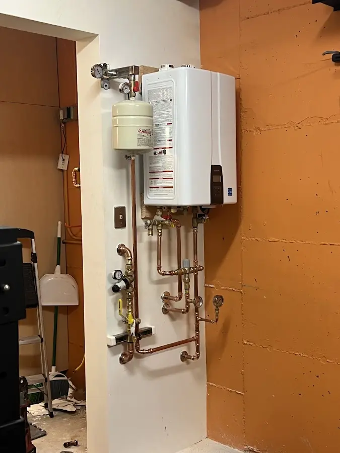 Plumbing technician inspecting water heater connections in Little River